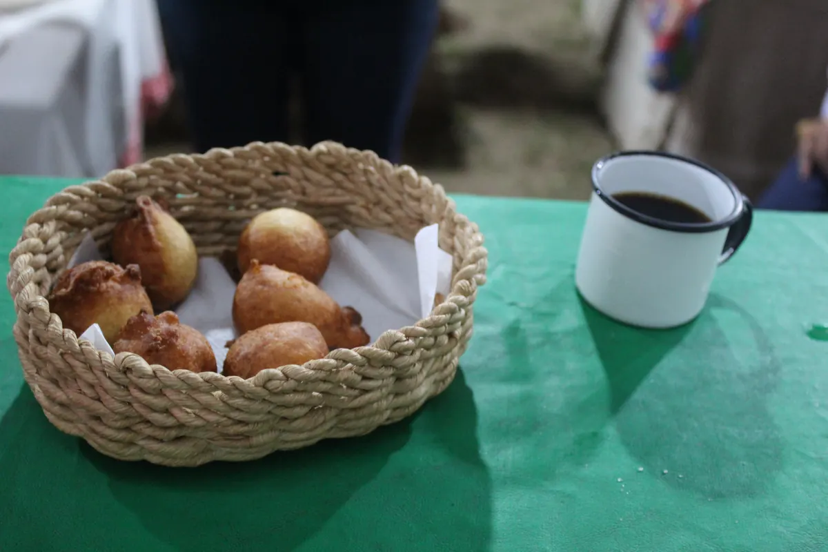Cesta de bolinhos de chuva ao lado de uma caneca de café
